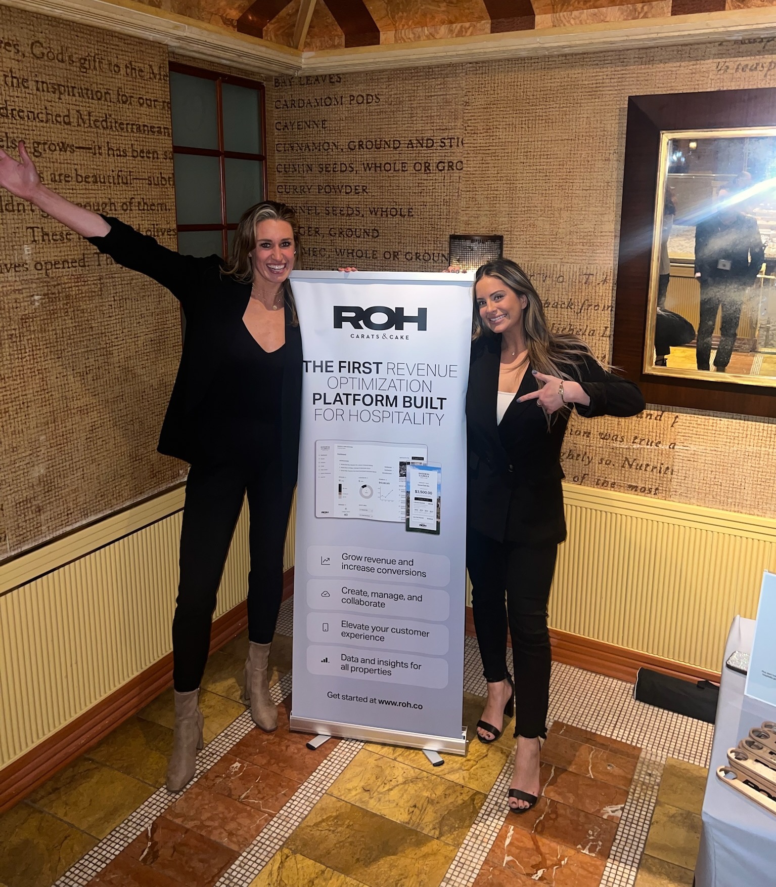 The ROH sales team next to the ROH banner at the Springboard Leadership Hospitality Conference.